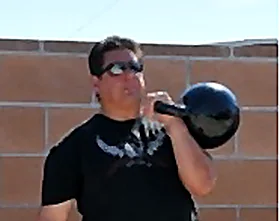 Joe Chalakee racking a kettlebell at the shoulder